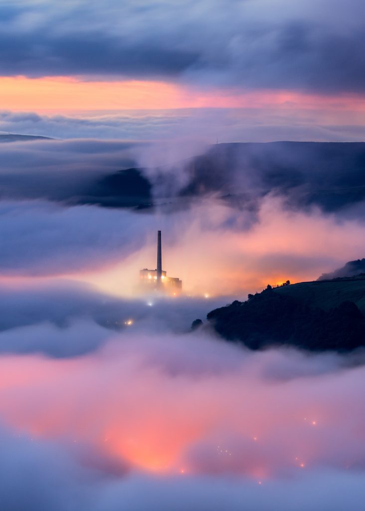 Pre-dawn mist and lights looking down on the village of Castletown and the Hop Cement Works, Peak District.